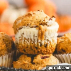 Pumpkin Cream Cheese Swirl Muffins 3 A close up of a pumpkin cream cheese muffin with a creamy cheesecake center showing through the middle.
