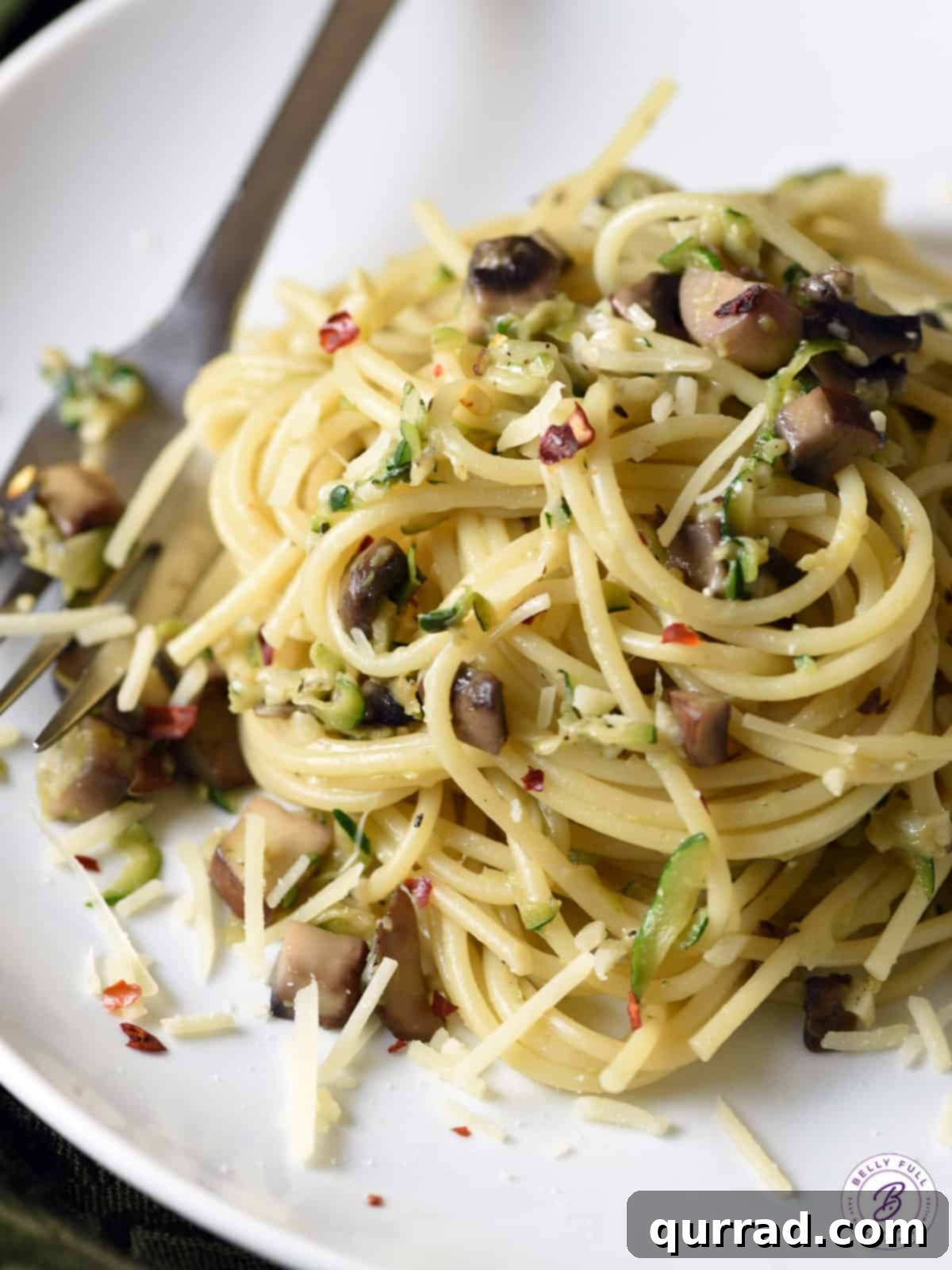 Savory Zucchini Mushroom Pasta 2 A generous serving of pasta tossed with freshly sautéed zucchini and mushrooms, garnished with herbs.