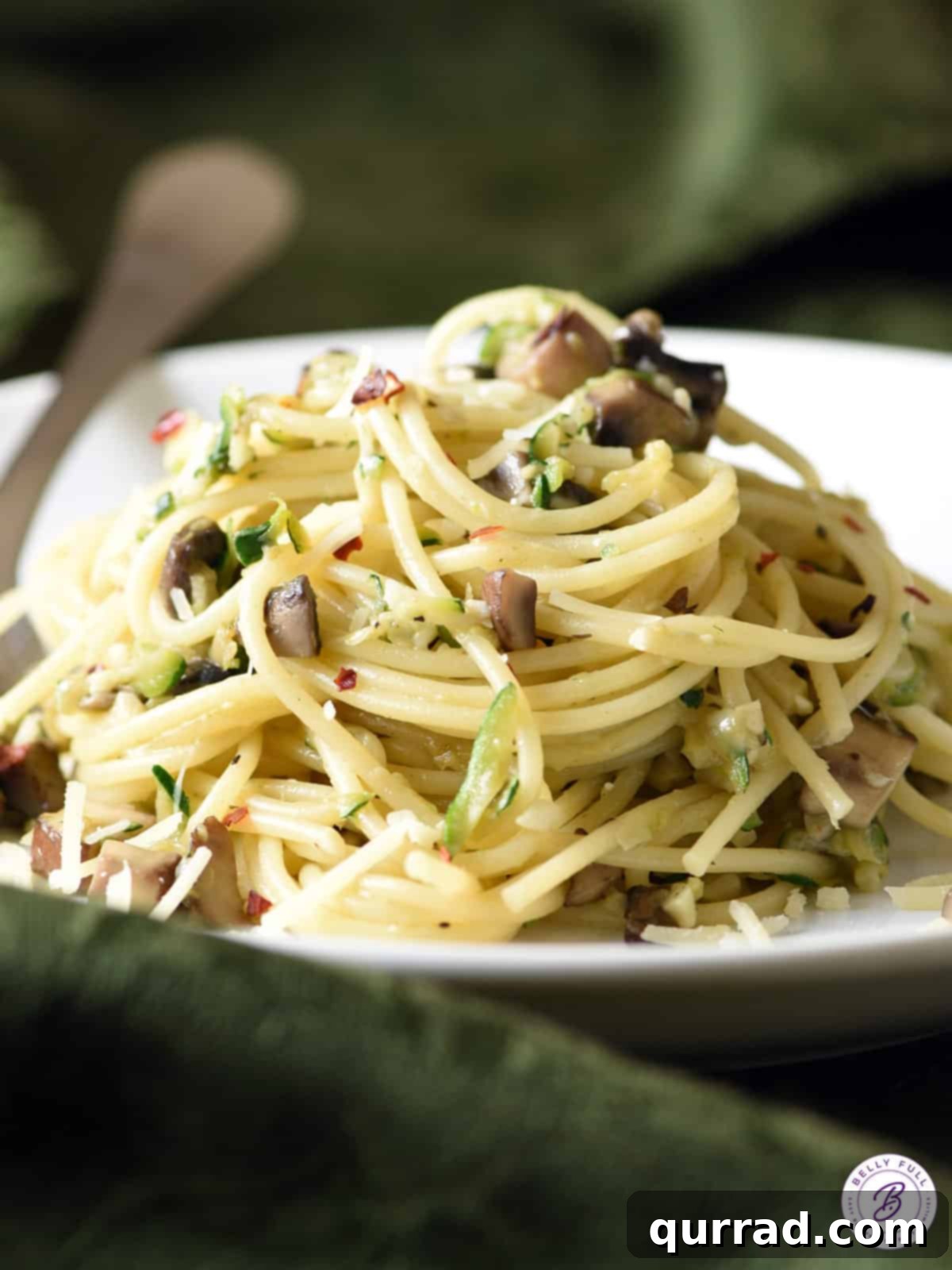 Savory Zucchini Mushroom Pasta 8 A beautifully presented mound of Mushroom Zucchini Pasta with visible pieces of zucchini and mushrooms.