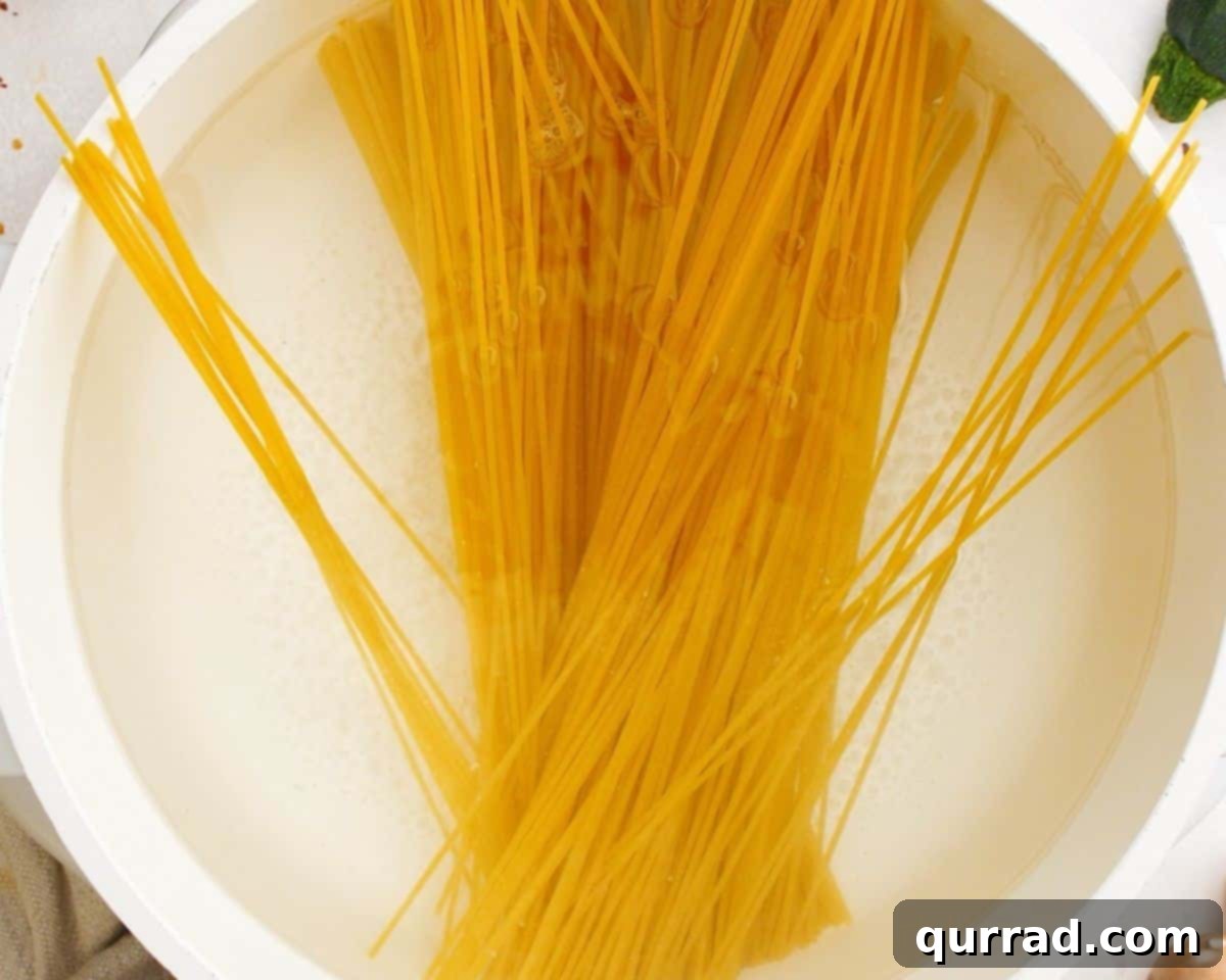 Savory Zucchini Mushroom Pasta 4 Spaghetti cooking in a large pot of boiling water.