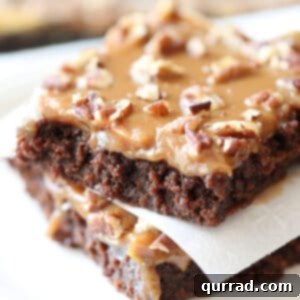 Two squares of caramel brownies stacked
