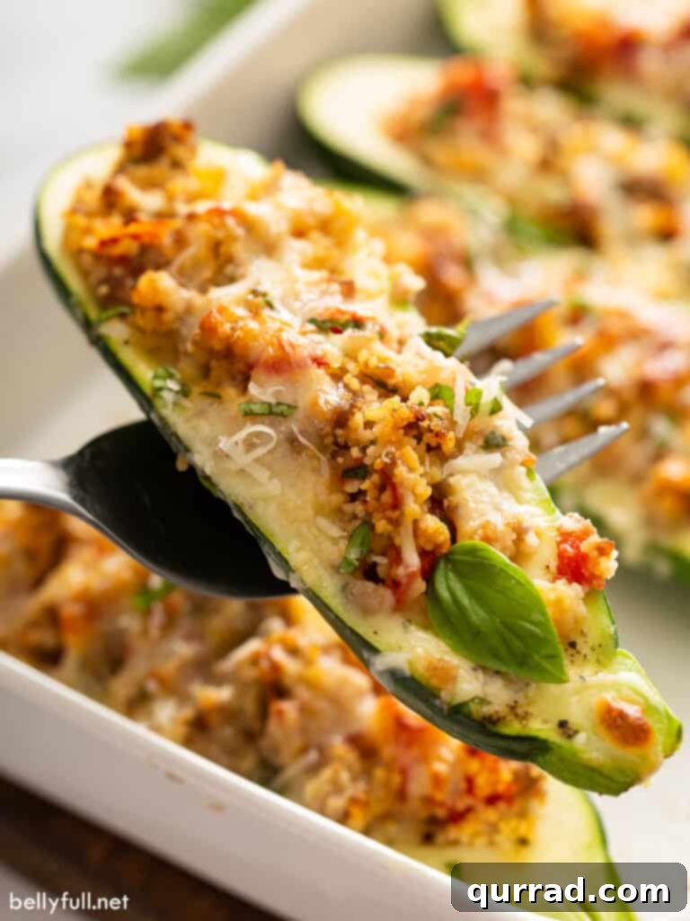 Hearty Italian Zucchini Boats 14 Close-up shot of a fork holding a piece of Italian sausage stuffed zucchini, showing the delicious filling and melted cheese.