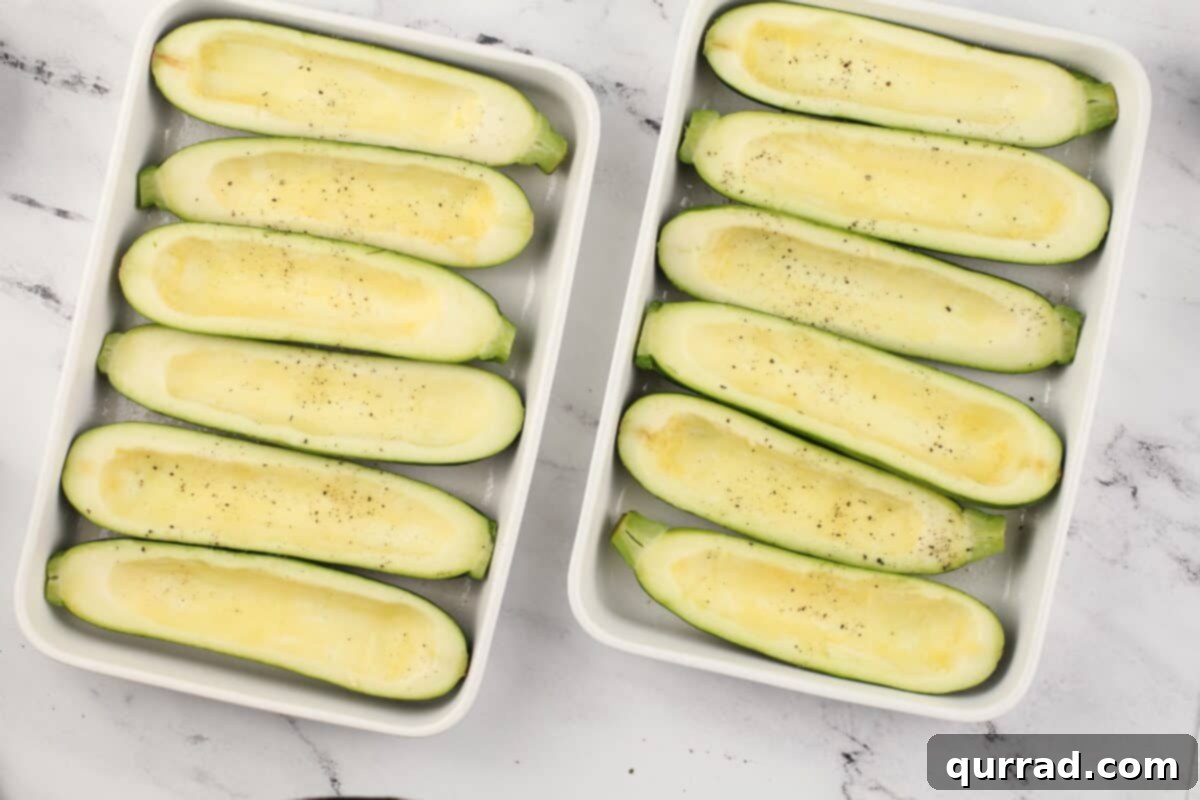 Hearty Italian Zucchini Boats 7 Hollowed out zucchini halves, seasoned with salt and pepper, arranged in two white baking dishes.