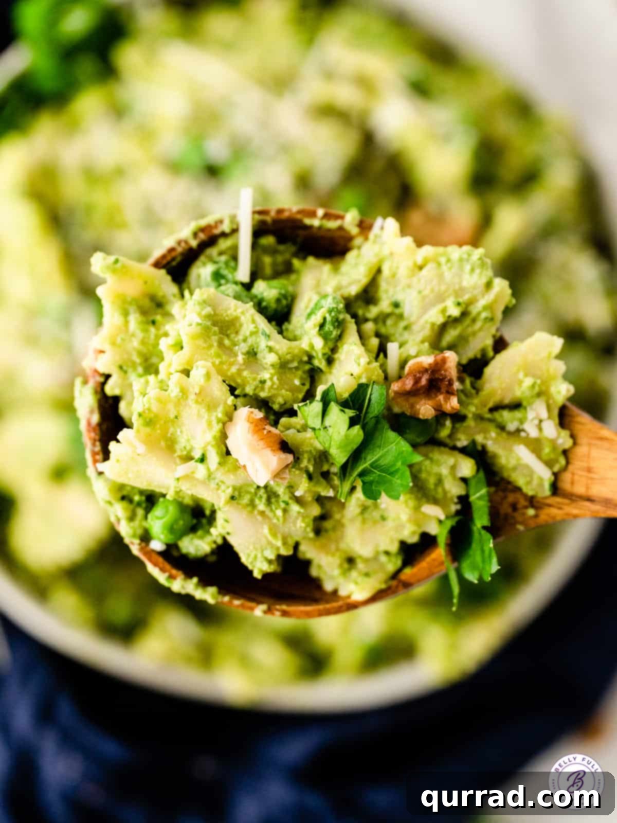 wooden serving spoonful of pasta with pesto