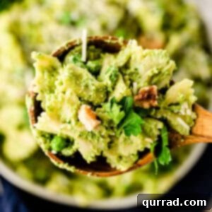 wooden serving spoonful of pasta with pesto