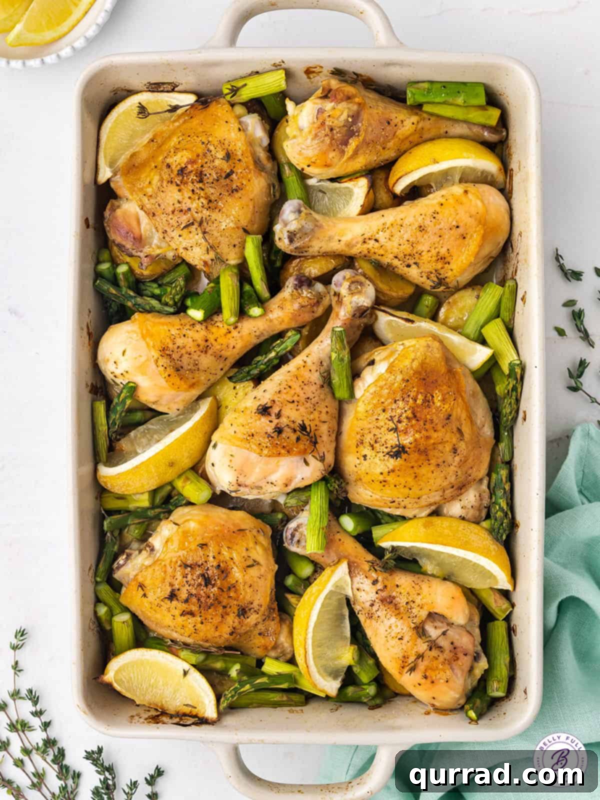 Effortless One-Pan Chicken Meal 3 One-Pan Roast Chicken Dinner spread out with roasted potatoes, tender asparagus, and bright lemon slices, highlighting the variety of ingredients cooked together.