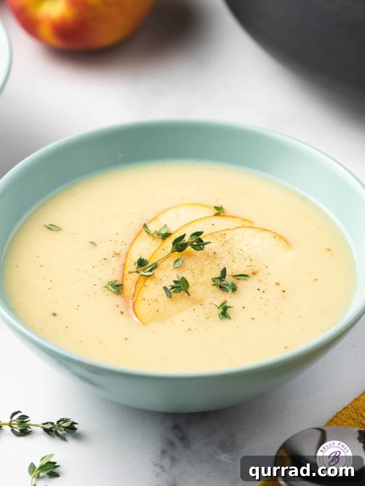 Velvety Parsnip Puree 2 bowl of parsnip soup garnished with sliced apple and thyme leaves