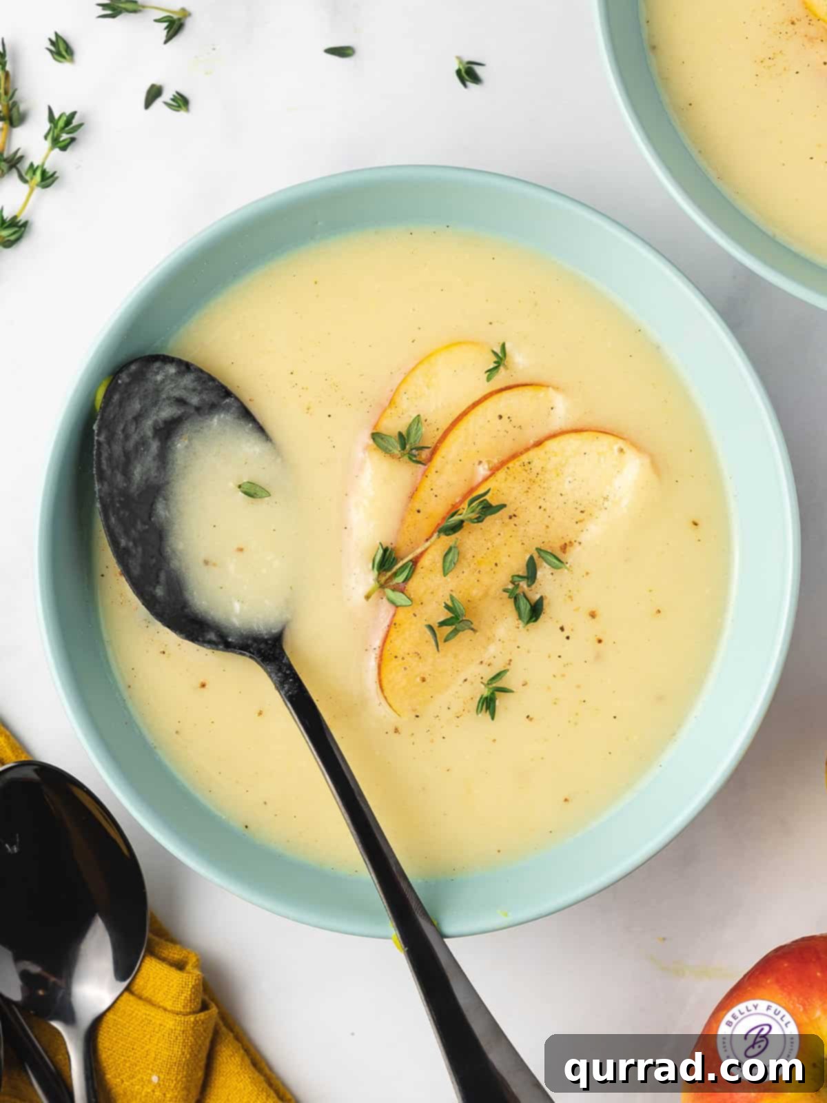 Velvety Parsnip Puree 5 Bowl of parsnip soup with apple slices and thyme sprigs