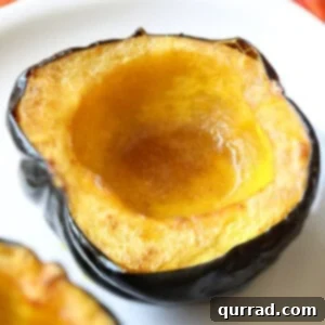 Close-up of a perfectly roasted acorn squash half, glistening with melted butter and brown sugar, ready to be served.