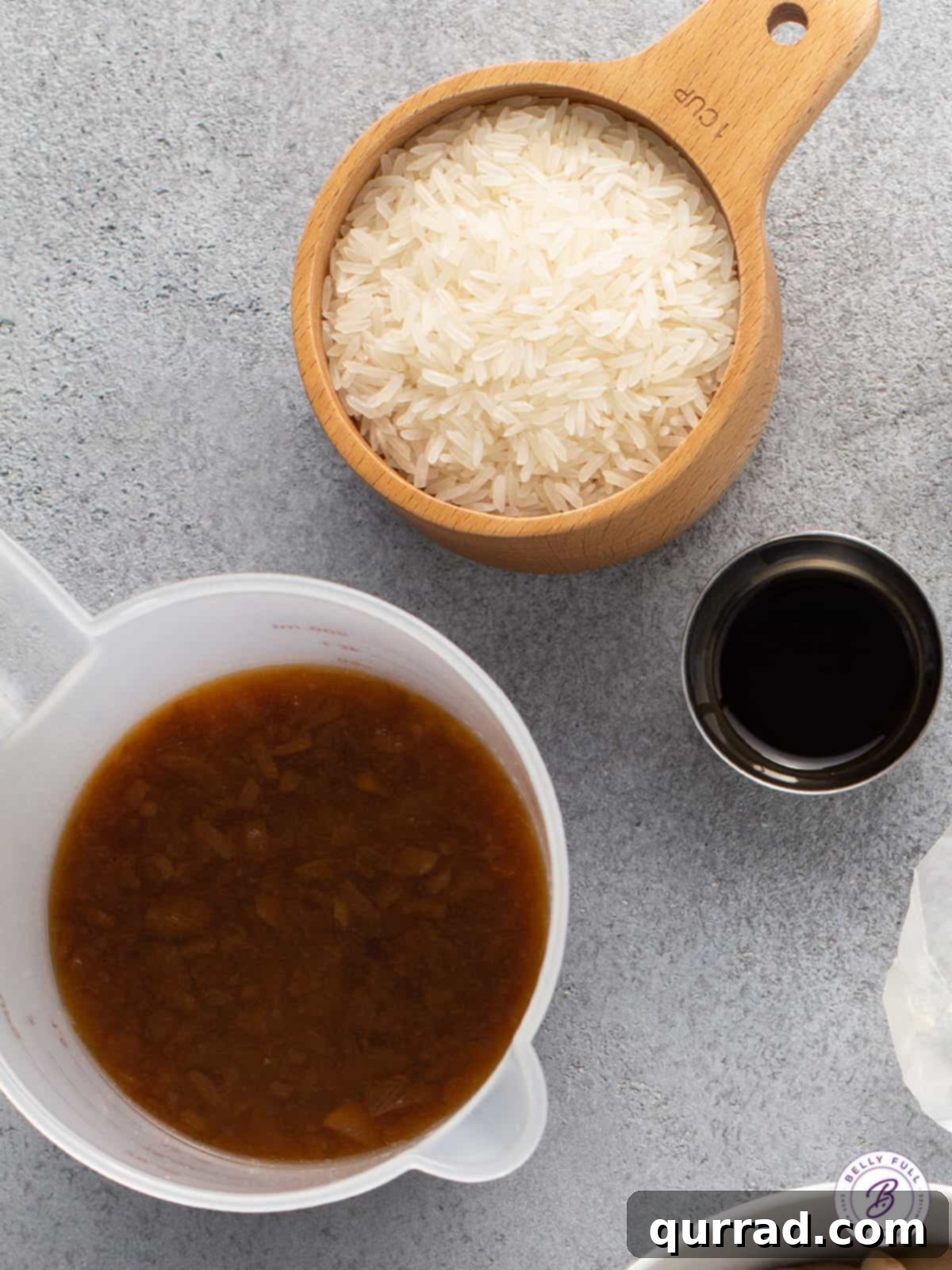 Flawless Rice Pilaf 3 Measuring cups containing long grain white rice and a rich beef broth, illustrating the key ingredients for flavorful rice pilaf.