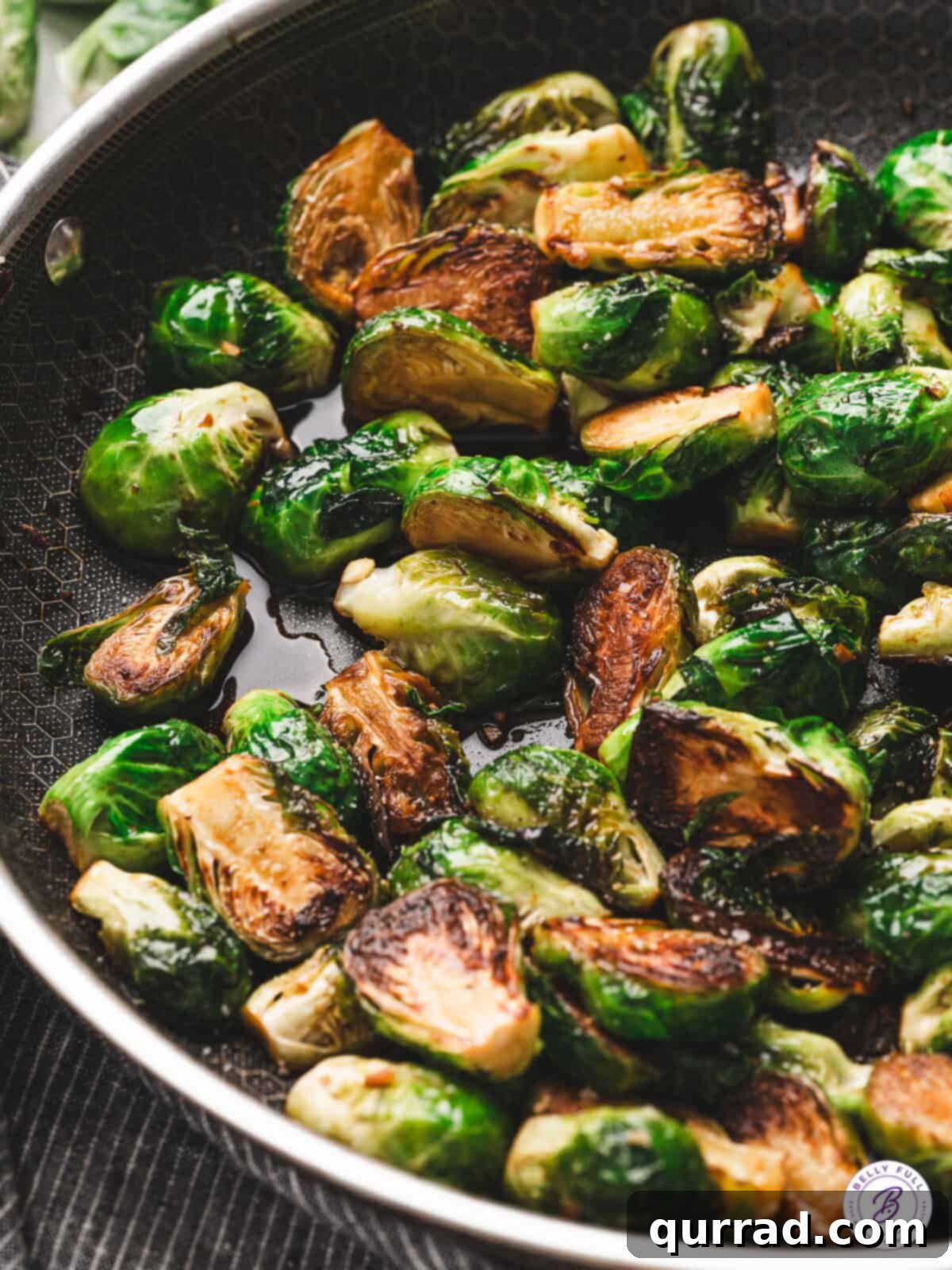 Caramelized Molasses Brussels Sprouts 2 Close-up of sautéed Brussels sprouts in a skillet, golden brown on the cut sides and coated in a glossy molasses glaze.