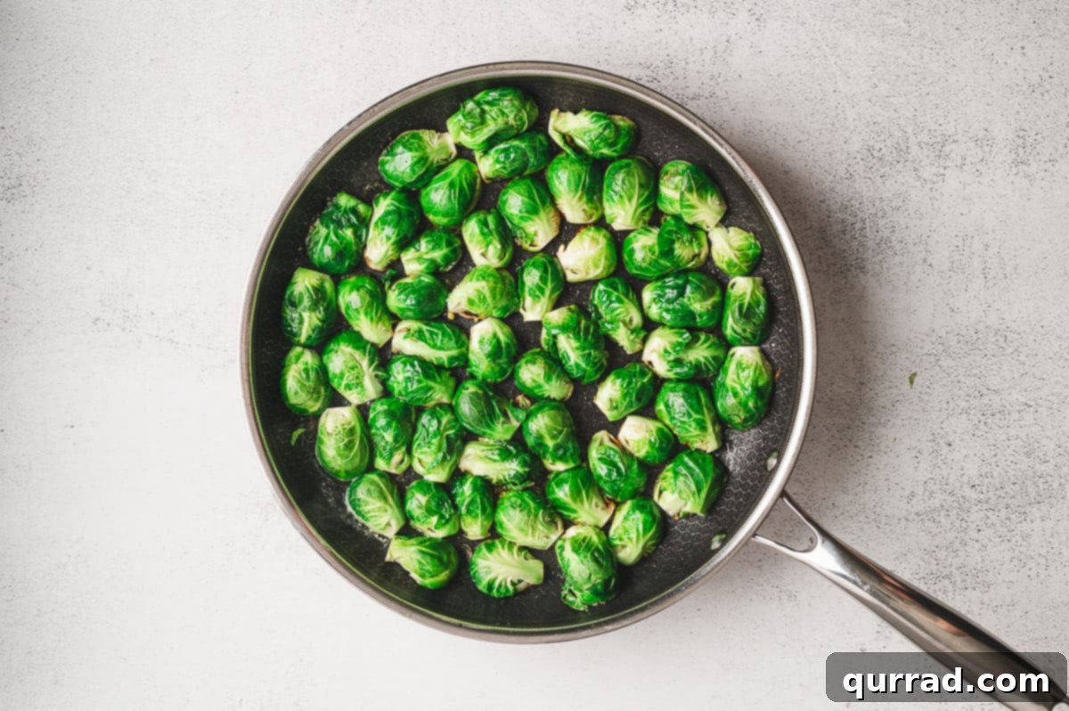 Caramelized Molasses Brussels Sprouts 5 Raw halved Brussels sprouts arranged cut side down in a large skillet, ready to be seared.