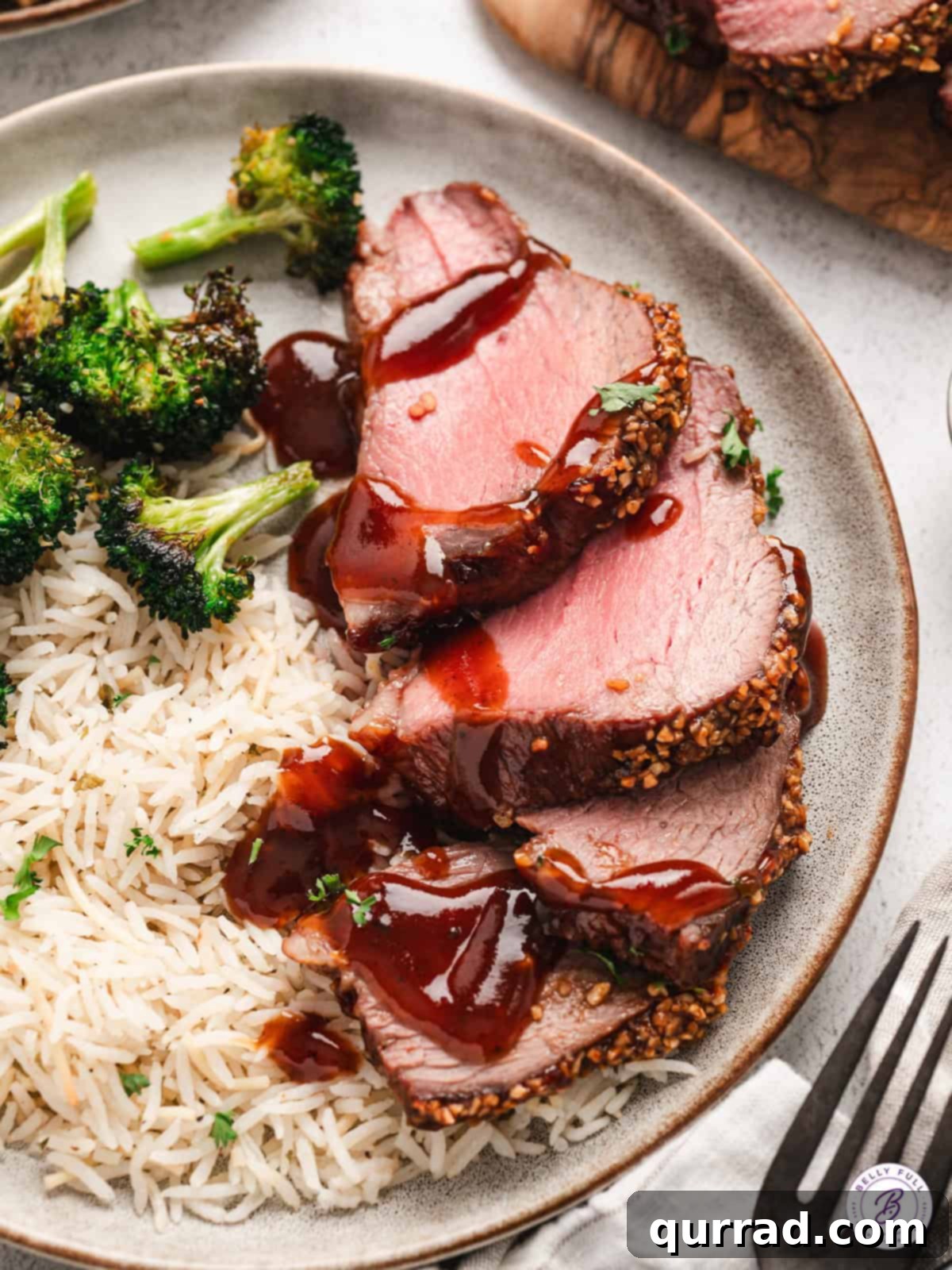 Close-up of perfectly sliced roasted Tri-Tip on a plate with extra glaze, highlighting its succulence