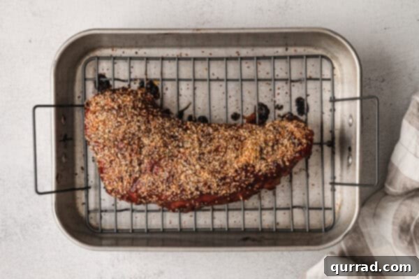Roasted glazed tri tip with layer of dried garlic on rack, freshly out of the oven