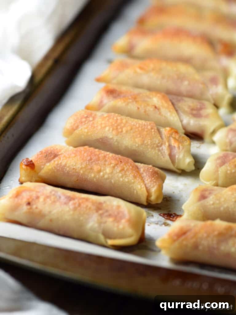 Crispy Salami Mozzarella Poppers 3 Wonton wrappers being stuffed with mozzarella string cheese on a baking sheet, ready for baking.