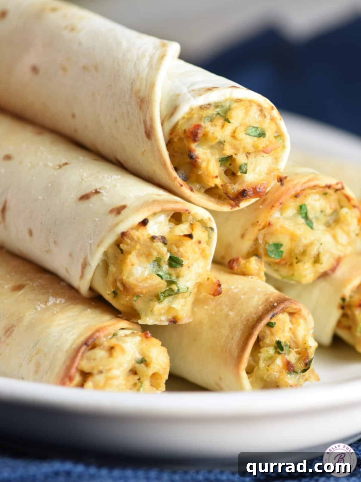 Golden Baked Chicken Taquitos 4 stack of homemade baked chicken taquitos on white plate