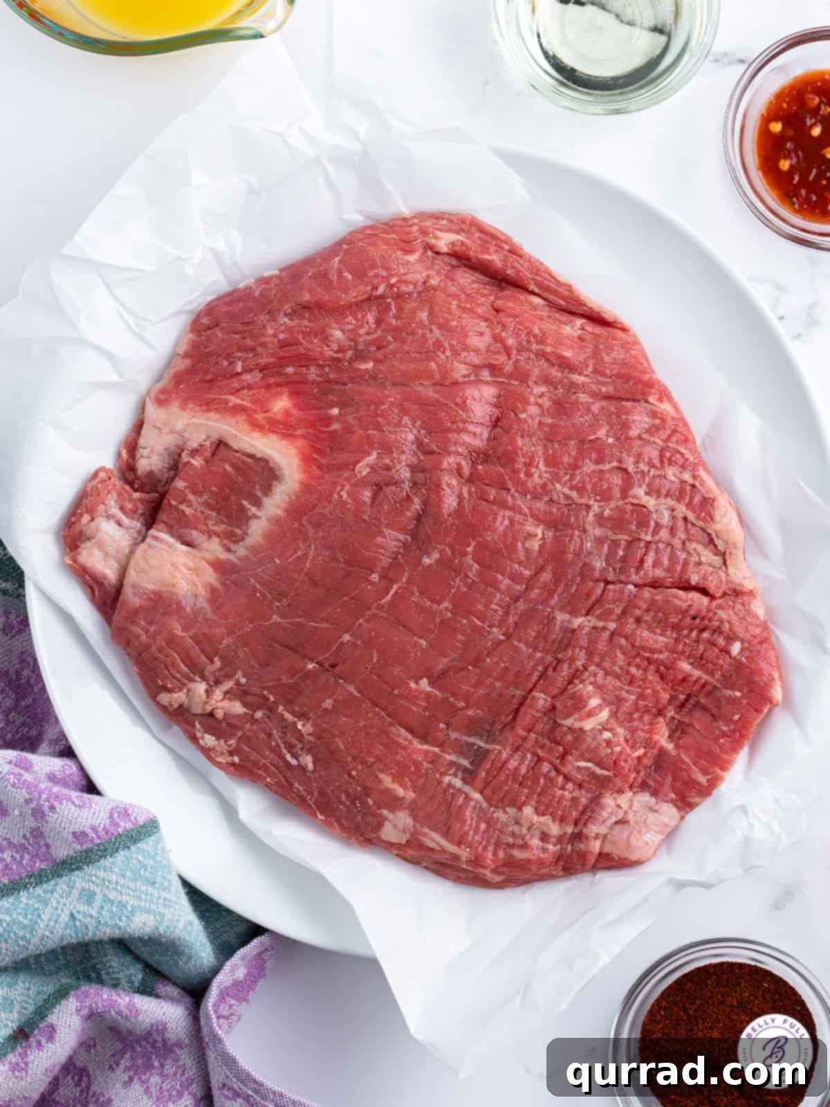 Slow Cooker Mongolian Beef 3 raw flank steak on parchment paper