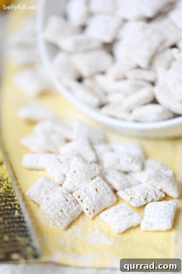 15-minute Lemon Muddy Buddies with Rice Chex cereal, white chocolate, lemon juice, and lemon zest. Try not to eat all of it in one sitting! #muddybuddies #puppychow #lemonmuddybuddies #lemonpuppychow #lemondesserts Lemon Muddy Buddies scattered on a yellow napkin next to a whole lemon and a zester