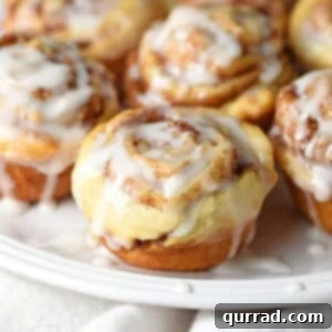 mini iced cinnamon rolls on a white plate, close-up view