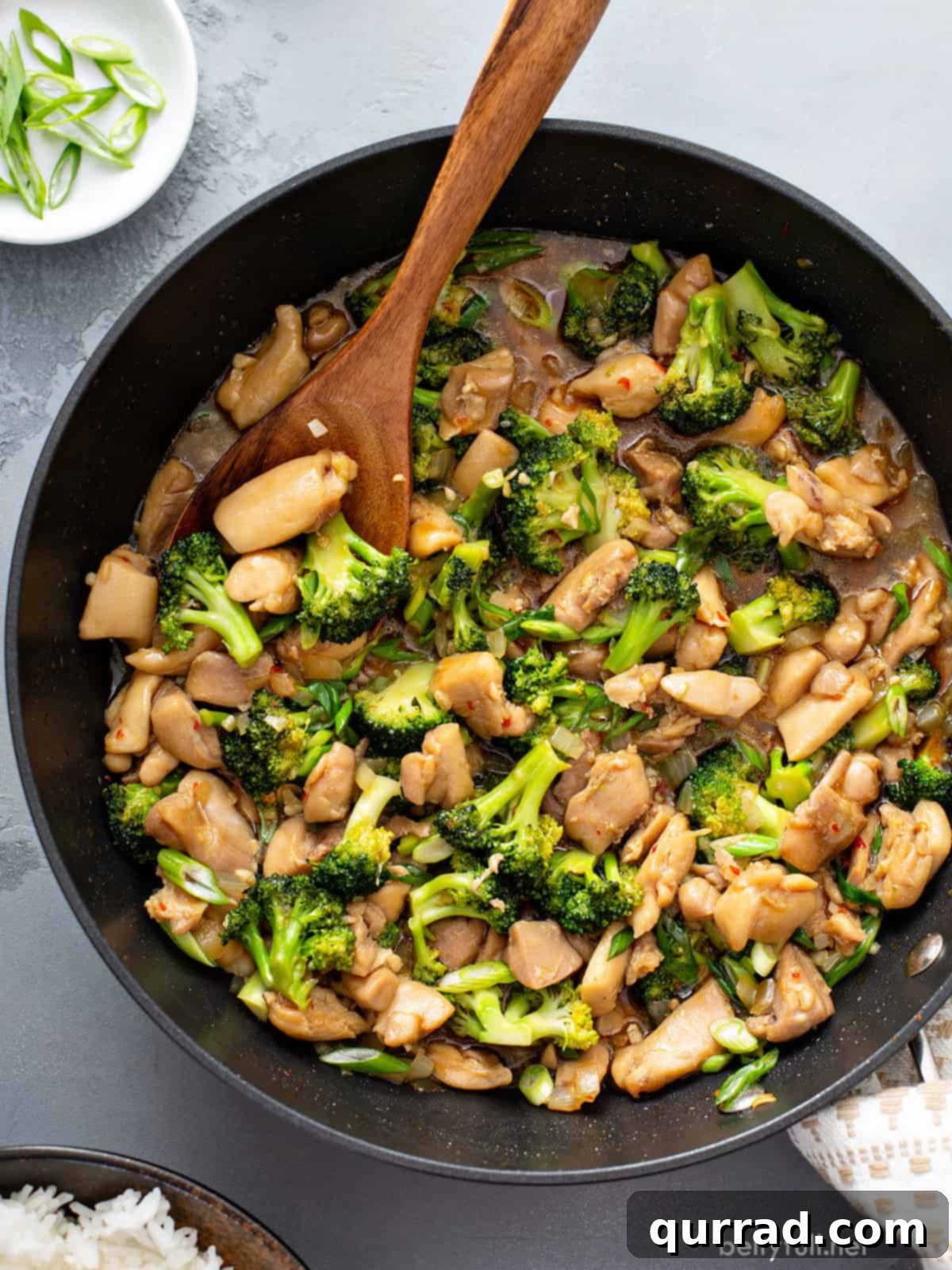 Savory Chicken and Broccoli Stir Fry 2 Overhead chicken and broccoli stir fry in skillet, garnished with green onions.