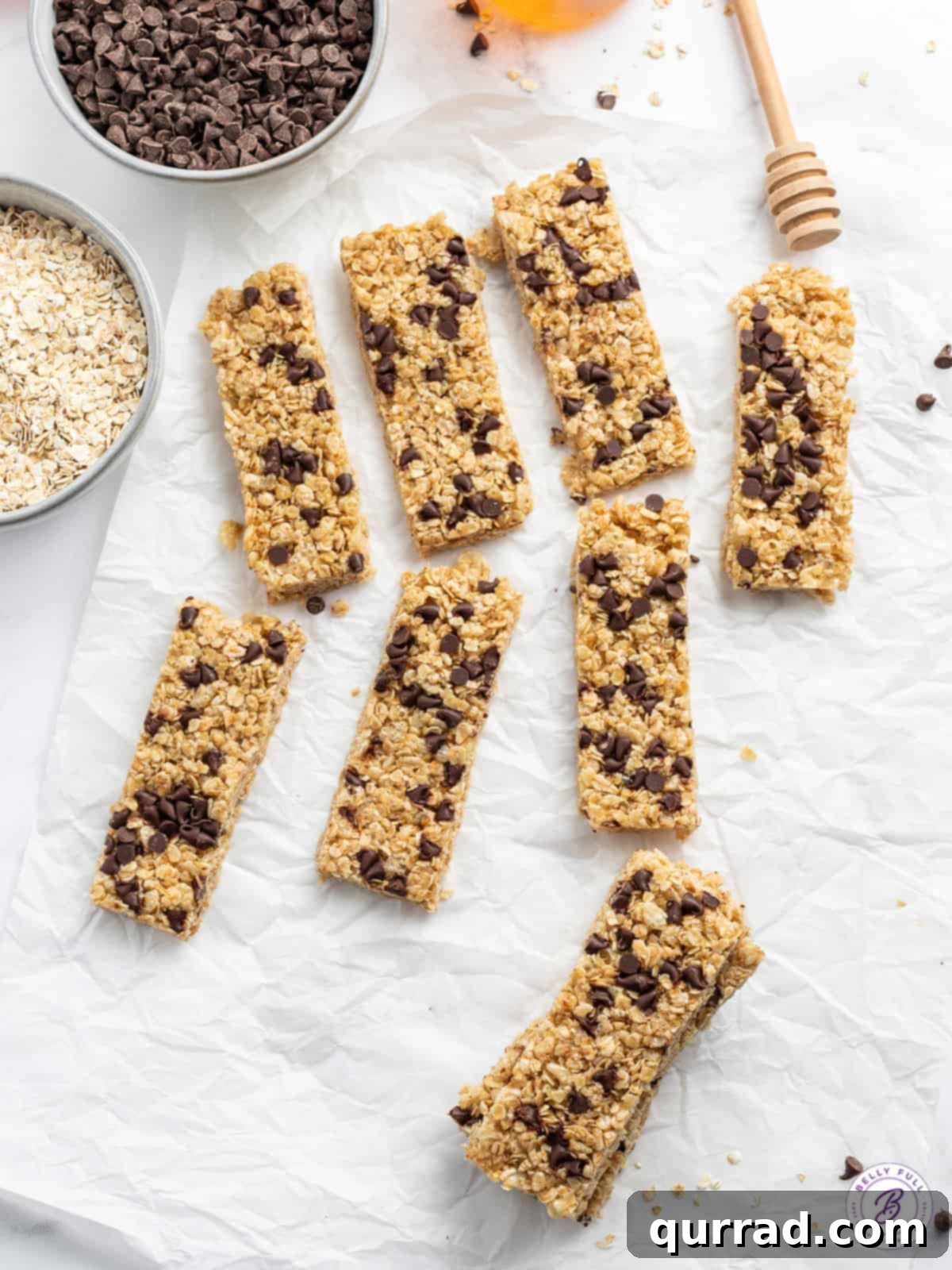 Wholesome Homemade Snack Bars 7 The granola bar mixture pressed firmly into a parchment-lined 8x8 baking pan, with mini chocolate chips sprinkled evenly across the top.
