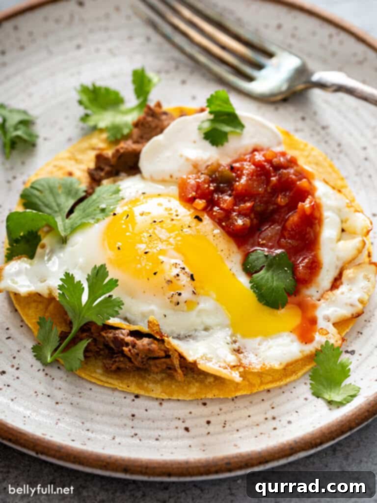 Fiesta Morning Eggs 2 Huevos Rancheros on plate with fork, showing a runny yolk
