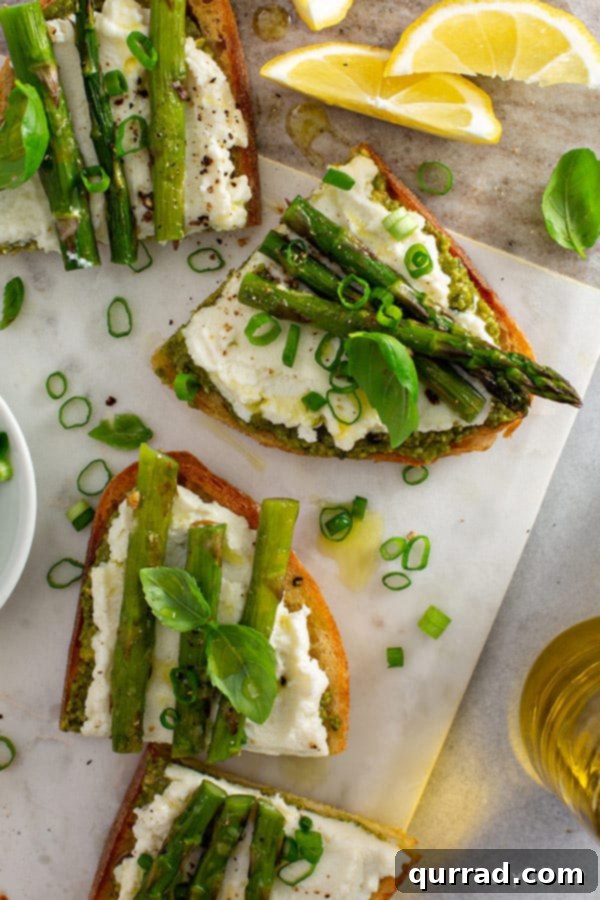 Overhead view of roasted asparagus and ricotta crostini arranged beautifully on a serving platter, suitable for appetizers