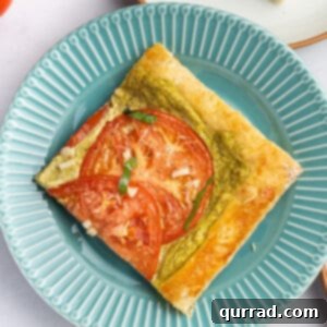A vibrant blue plate holding a square slice of the freshly baked tomato basil tart.