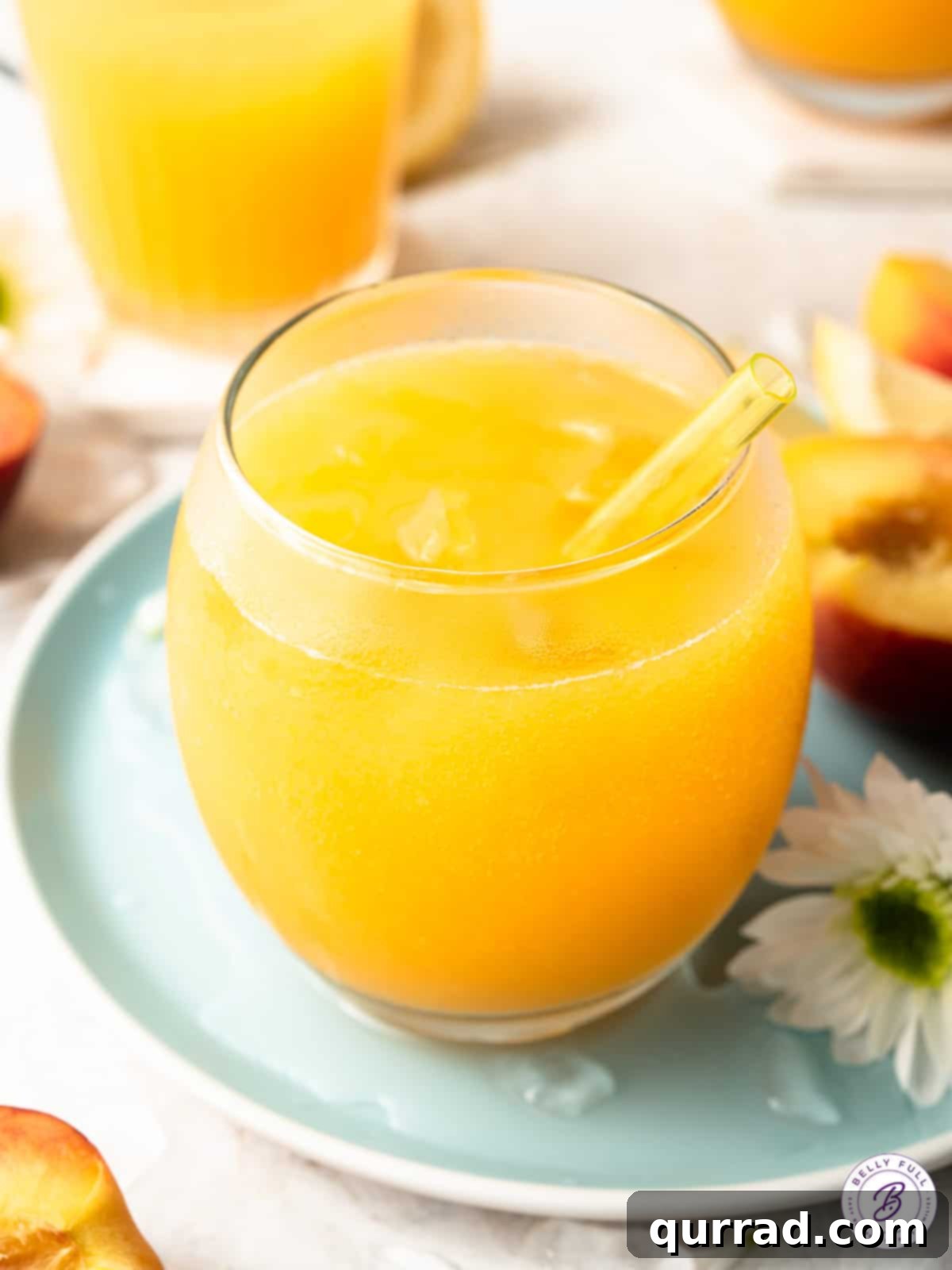 Glass of peach flavored lemonade with a straw and garnish, ready to drink