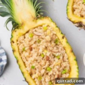coconut rice piled inside fresh hollowed out pineapple half with spoon