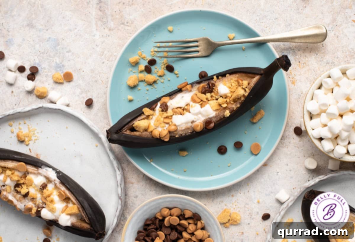 An array of ingredients for s'mores banana boats including bananas, chocolate chips, butterscotch chips, marshmallows, and graham crackers, ready for assembly.