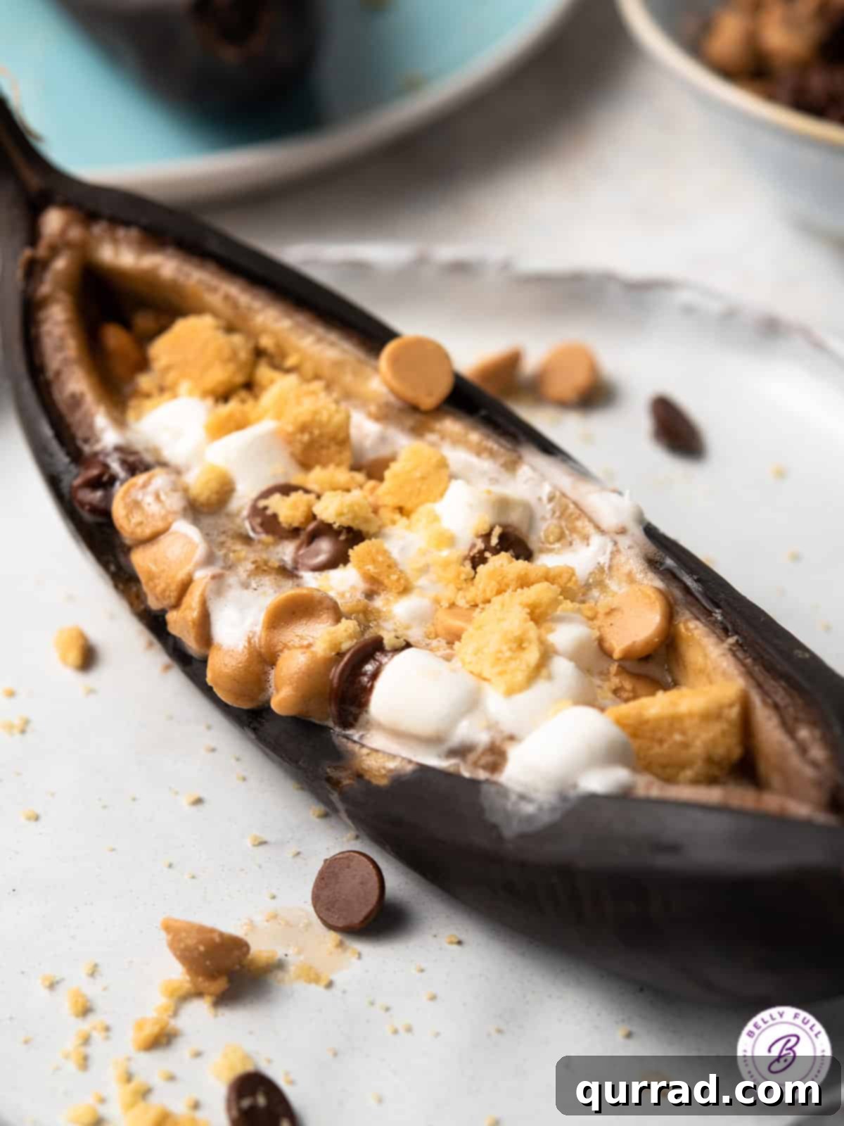Close-up of a perfectly roasted banana boat with golden-brown marshmallows, melted chocolate, and crushed graham crackers.