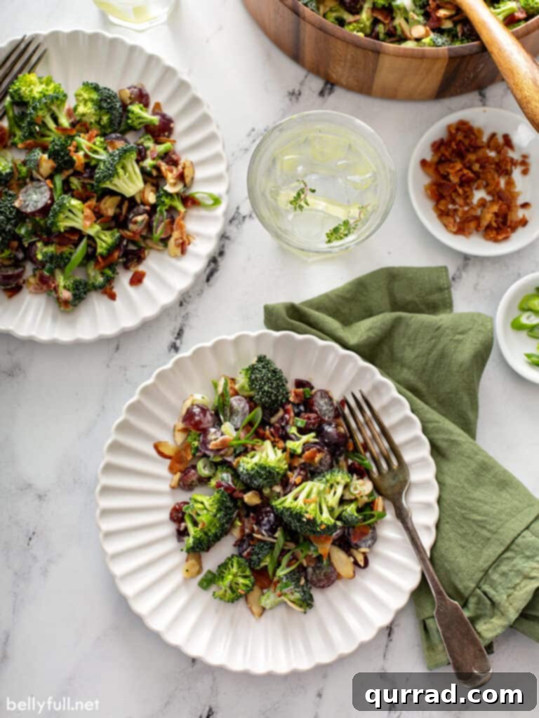 Sweet & Tangy Broccoli Crunch 3 A portion of creamy broccoli salad elegantly presented on a white plate, highlighting its fresh and inviting appearance.