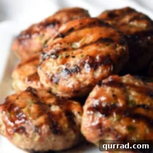 grilled pork sliders piled on white serving plate