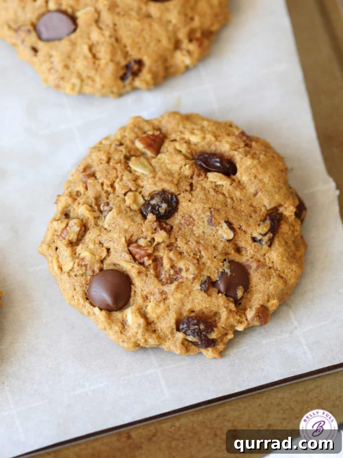 Rise and Shine Cookies 2 A large, inviting breakfast cookie adorned with chocolate chips and nuts, resting on parchment paper, ready to be enjoyed.