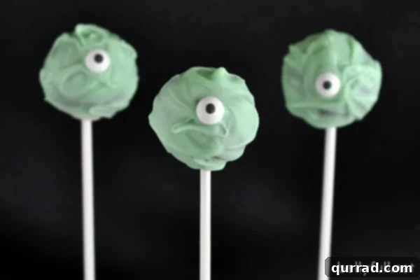 Halloween Cyclops Cake Pops 2 A plate of green one-eyed monster cake pops with googly eyes