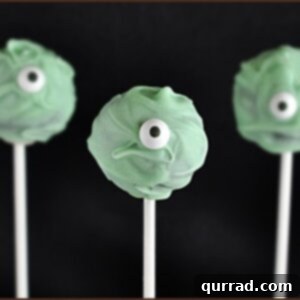 Halloween Cyclops Cake Pops 5 Green one-eyed monster cake pops on a stand