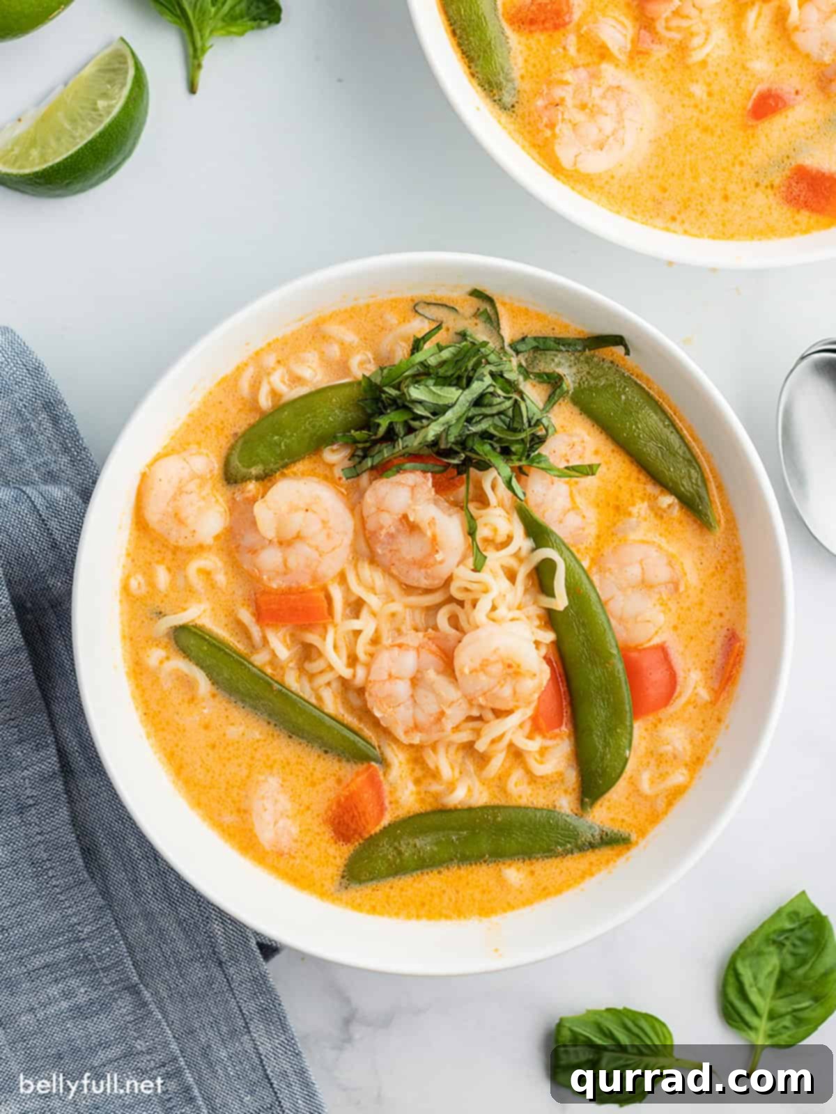 Creamy Thai Coconut Curry Soup 2 Vibrant Thai Curry Soup served in a white bowl, garnished with fresh basil leaves, ready to be enjoyed.