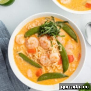 Overhead view of Thai Curry Soup in a white bowl, main recipe image.
