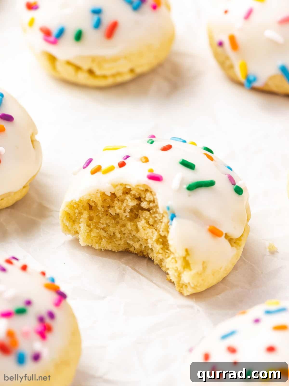 Sweet Italian Delights 5 A perfectly iced Italian Cookie with a bite taken, revealing its soft, tender interior, demonstrating the irresistible quality of this classic treat.