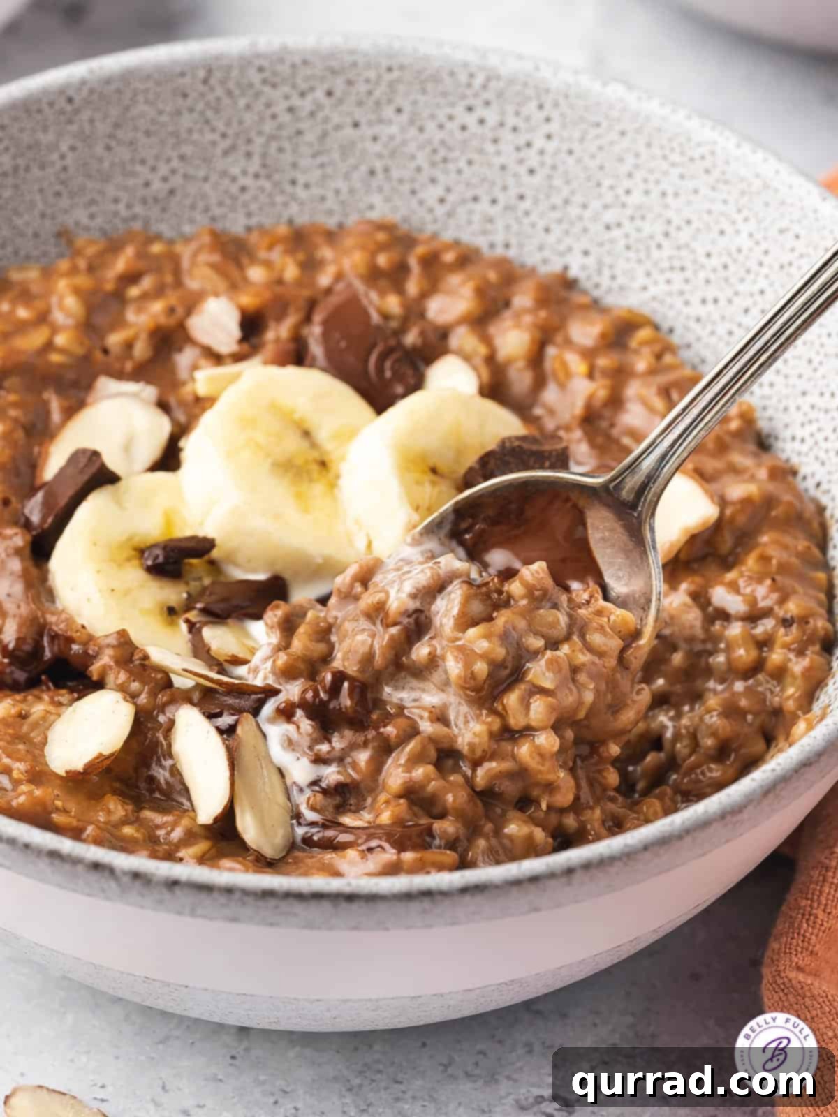 Cocoa-Almond Steel Cut Oatmeal A spoonful of rich chocolate steel cut oats, showing the creamy texture and banana topping.
