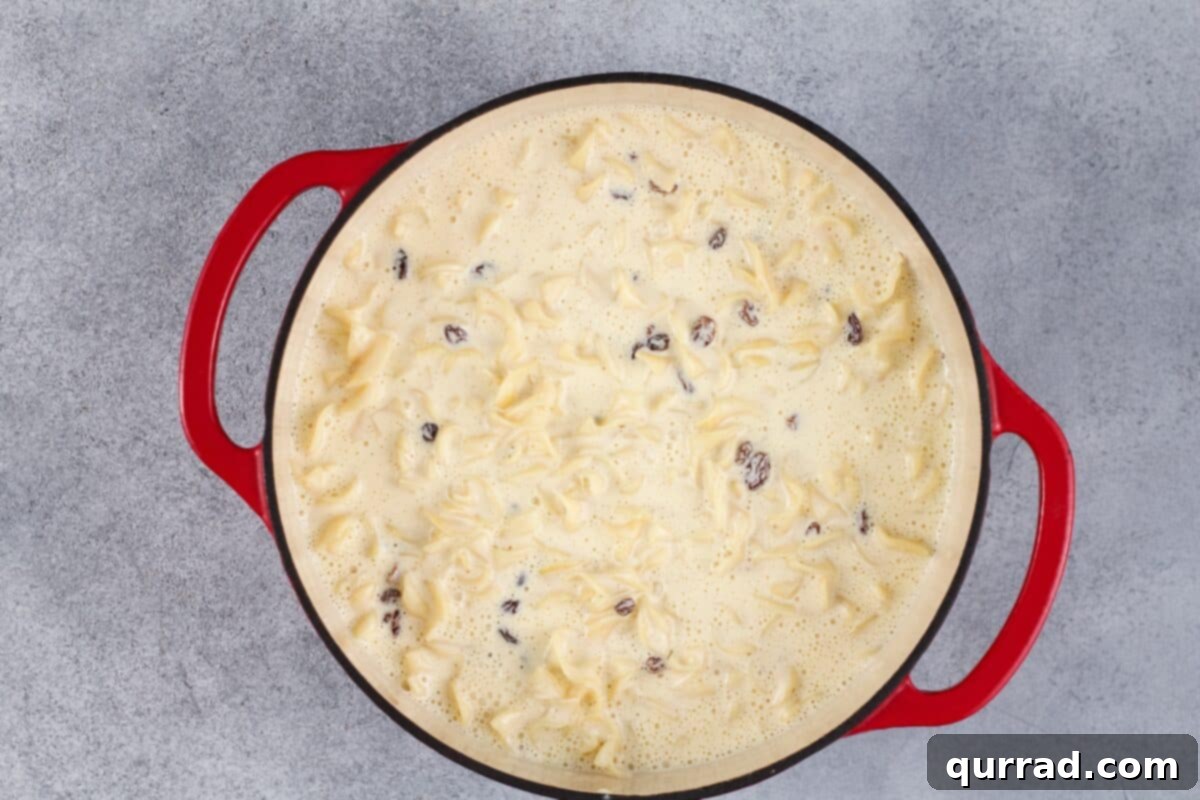 Golden Baked Noodle Pudding 8 Custard, noodles, and raisins in a pot.
