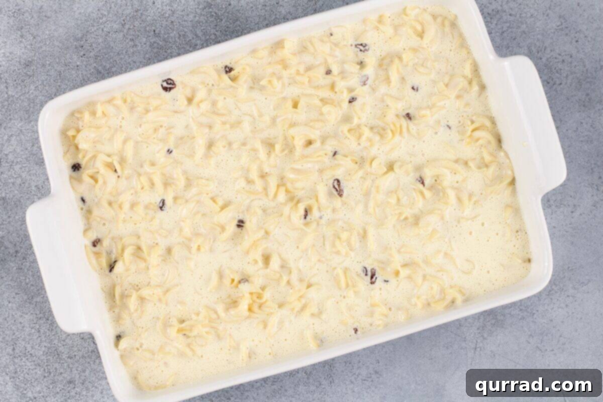 Golden Baked Noodle Pudding 9 Uncooked noodle kugel in a white baking dish.