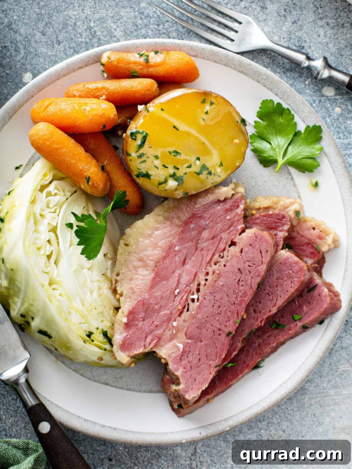 overhead 3 slices corned beef with vegetables on white plate