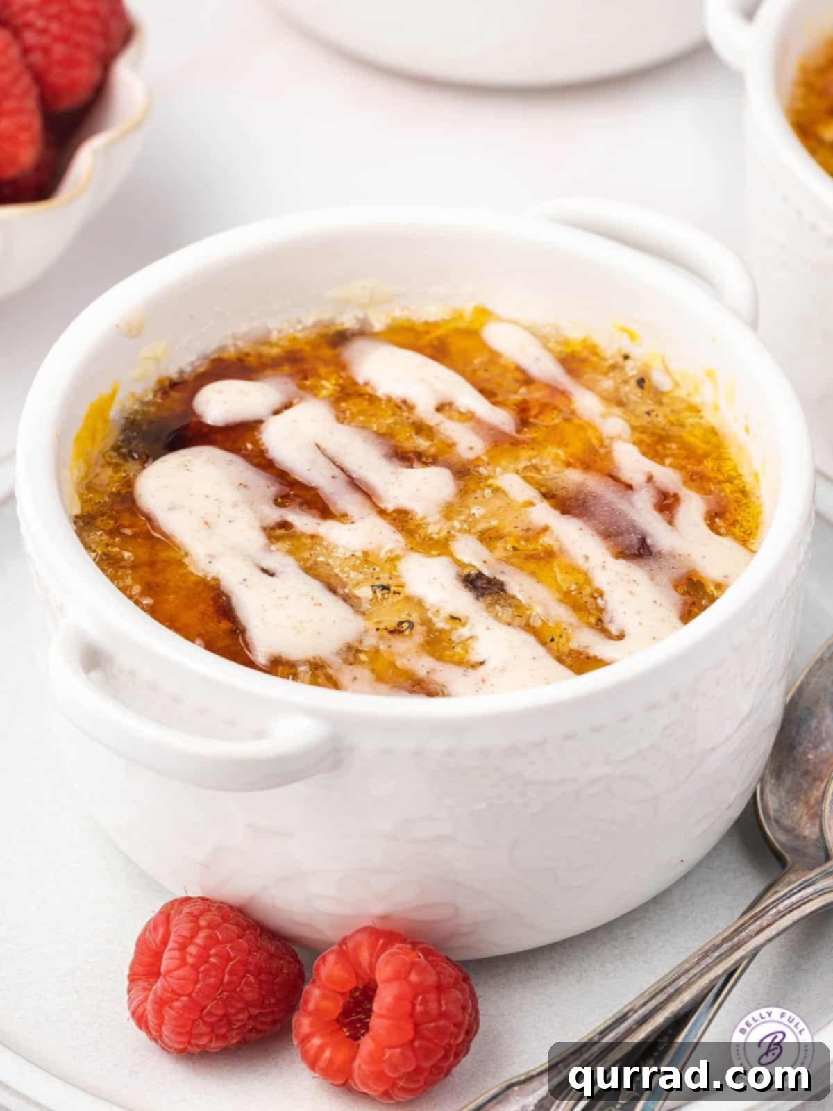 Golden Crusted Oatmeal 3 Close-up of oatmeal in a white ramekin, generously drizzled with maple cinnamon cream, highlighting the creamy texture and inviting presentation.