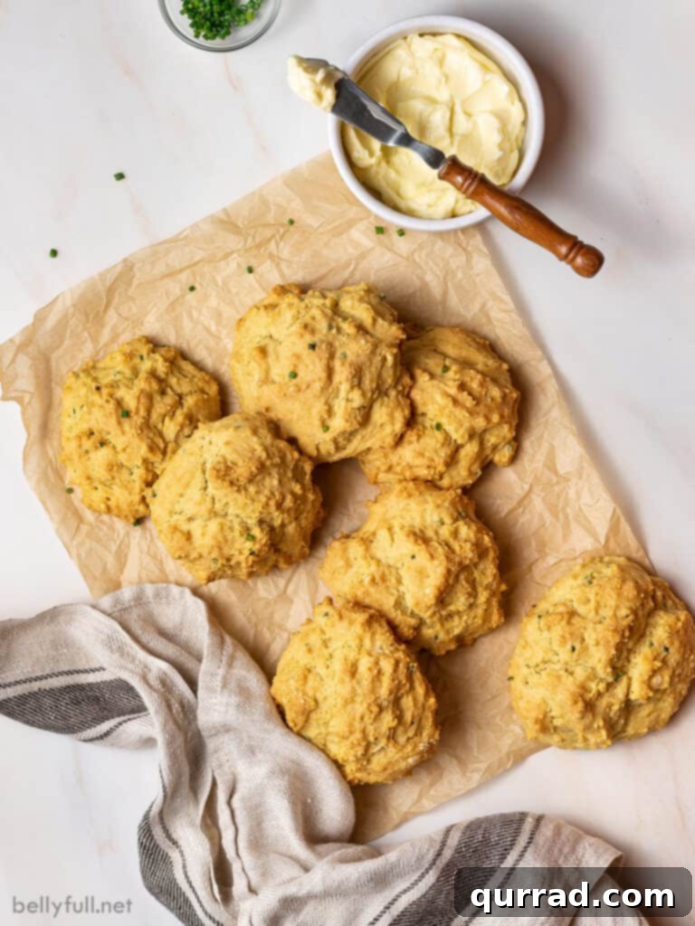 7 golden biscuits piled on brown parchment paper with butter knife