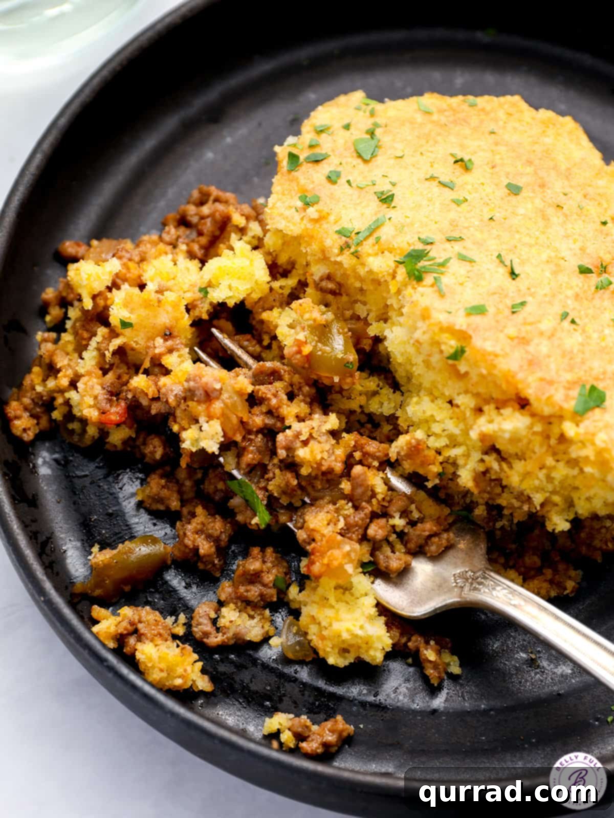 Golden Cornbread Sloppy Joe Pie 5 A scoop of Cornbread Sloppy Joe Skillet showing a perfect ratio of golden cornbread and rich sloppy joe filling on a plate with a fork.