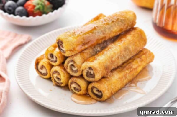 stack of French Toast Rolls on plate with maple syrup