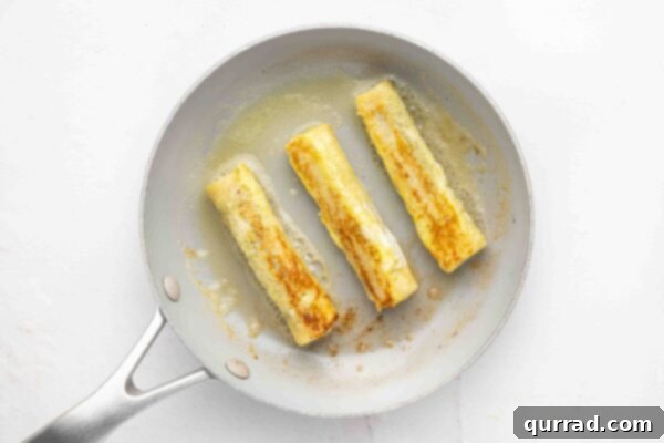 3 french toast rolls in fry pan with butter