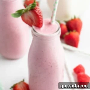 Creamy Strawberry Smoothie in tall glass with straw